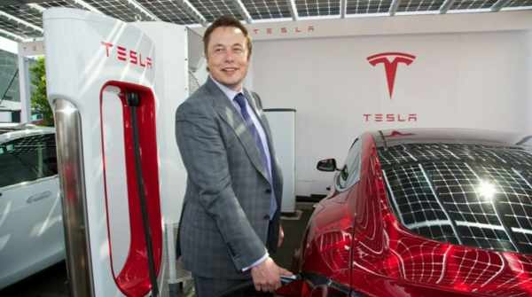 Elon musk rechargeant une Tesla dans un point de recharge